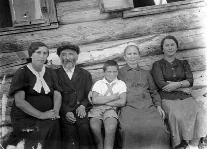 На фото в Лукомле дедушка, бабушка, тетя Даша. Я там тоже, так как моя мама беременна (на фото – слева). В середине брат Борис. Снято на фоне дедушкиного-бабушкиного дома летом 1937 года.